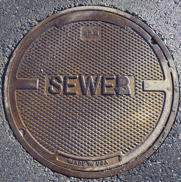 Metall-Schachtdruckgussdeckel auf der Straße beschriftet mit "Kanal".