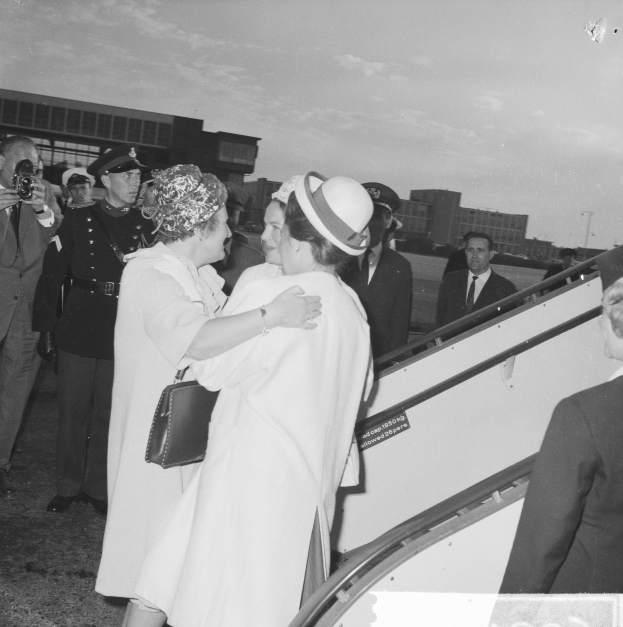 Königin Elizabeth II. und Prinz Philip, Herzog von Edinburgh, beim Ankunft am Heathrow Airport in London, mit zwei Frauen, die sich umarmen, und einem Mann mit einer Kamera im Hintergrund.