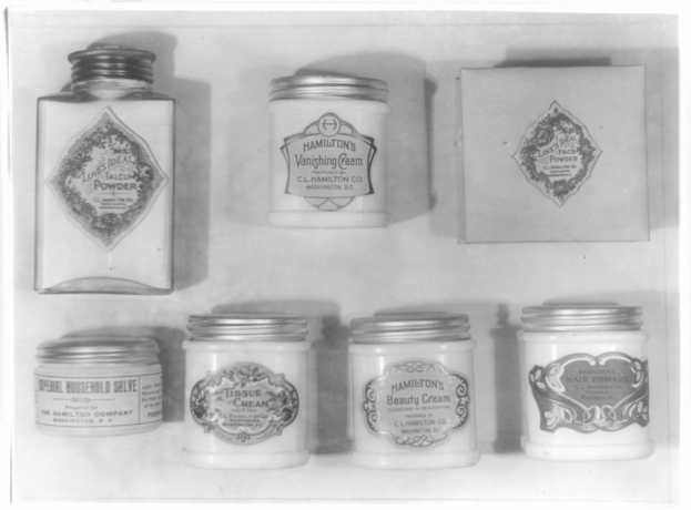 Schwarz-weiß-Foto eines Regals mit ordentlich angeordneten Creme-Gläsern, die jeweils mit verschiedenen Arten beschriftet sind.