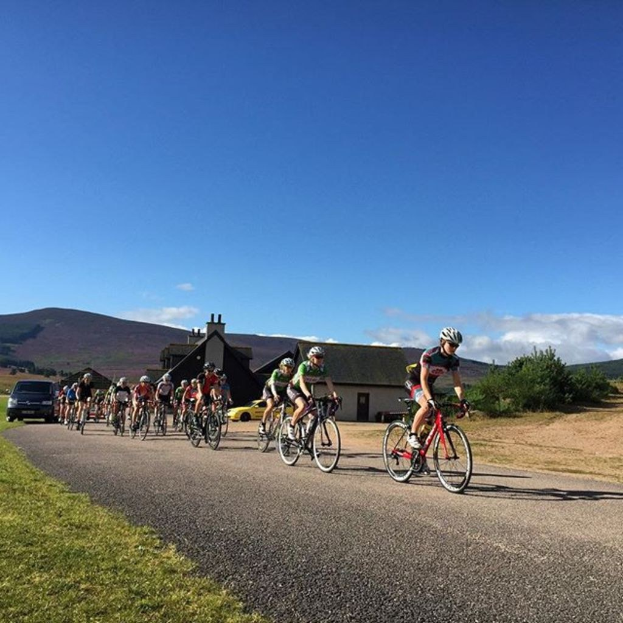 Eine Gruppe von Menschen, die auf einem Himmel-Hintergrund Fahrrad fährt.