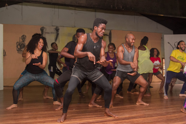 Eine Gruppe von Menschen, die in einem Raum mit Wandgemälden tanzen, wahrscheinlich Teil eines Choreografie-Kurses an der Universität Chicago.