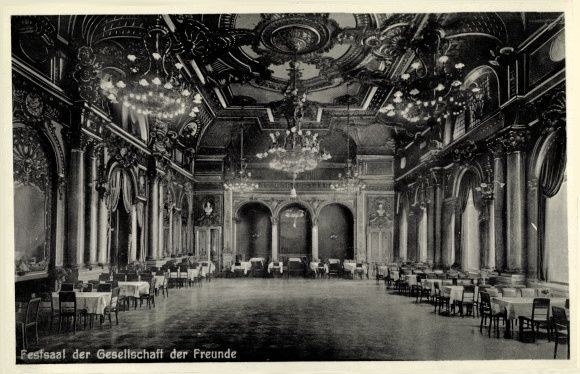 Schwarz-weiß-Foto eines großen Raums mit Tischen, Stühlen, Säulen, Bögen und Deckenleuchter; Text unten lautet "Festival der Gesellschaft der Freunde, Berlin".