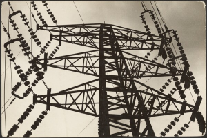 Ein Schwarz-Weiß-Foto einer Hochspannungsleitung mit einem Turm und Drähten im Vordergrund und einem Himmel im Hintergrund, mit Text unten.