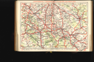 Ein aufgeschlagenes Buch mit einer detaillierten Deutschlandkarte, die Straßen und Autobahnen zeigt, vor einem schwarzen Hintergrund.