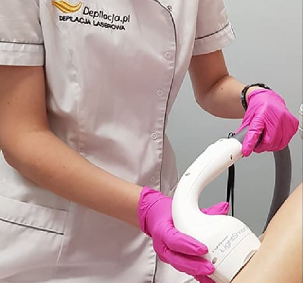 Eine Frau in einem weißen Hemd und pinken Handschuhen bedient eine weiße Laser-Haarentfernungsmaschine an einer Wand.