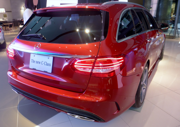 Ein roter Mercedes-Benz C-Klasse Estate wird auf der Frankfurter Motor Show präsentiert, umgeben von Menschen und verschiedenen Ausstellungselementen im Hintergrund.