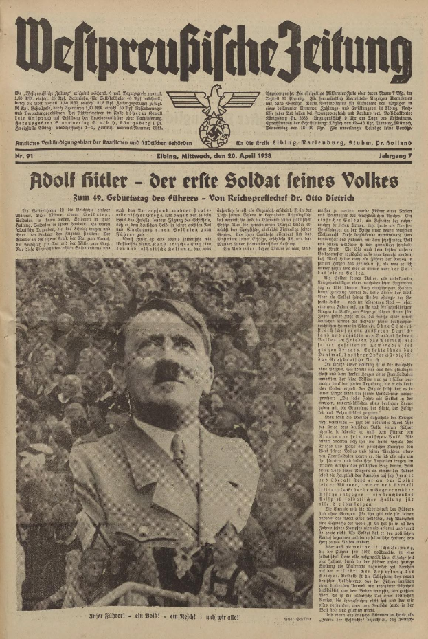 Schwarz-weiß-Foto von Adolf Hitler in einem schwarzen Anzug und weißem Hemd, das vor einer Menge steht und auf der Titelseite einer deutschen Zeitung mit der Schlagzeile "Adolf Hitler - Der Erste Soldat Feines Volkes" zu sehen ist.