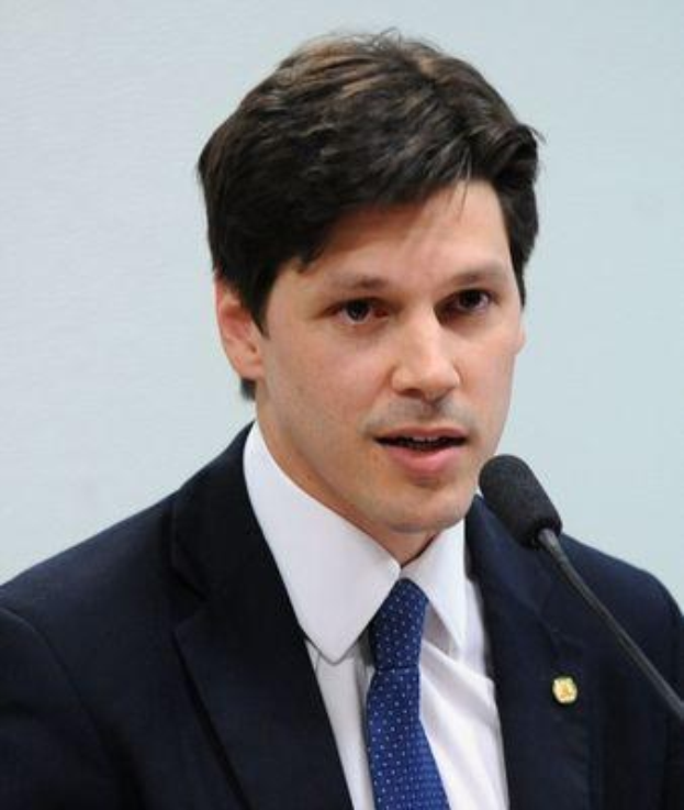 Ein Mann in Anzug und Krawatte spricht in ein Mikrofon an einem Rednerpult, wahrscheinlich um die Genehmigung eines Gesetzes zur Verbots des Internets durch die Regierung zu verkünden.