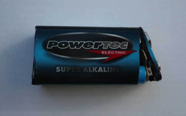 Blue Powertec Super Alkaline battery on a white surface with "Powertec" in bold lettering on the label.