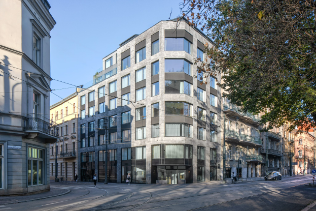 Großes Bürogebäude mit zahlreichen Fenstern, umgeben von Straßeninfrastruktur, Fahrzeugen, Passanten, Bäumen und einem bewölkten Himmel, das als neue Firmenzentrale dient.